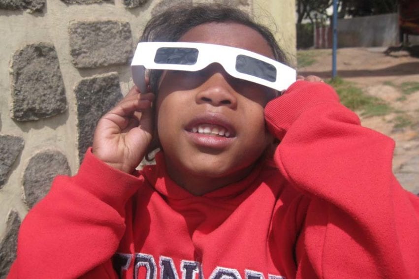 Les lunettes spéciales posées sur les yeux à l’aide de sa mère, une fillette de 7 ans regarde le ciel vers 11 h 10, heure àlaquelle la lune et le soleil avaient déjà fusionné.
