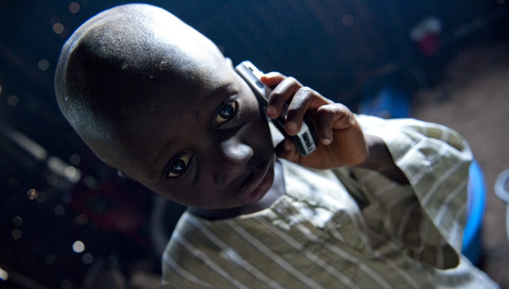 Young child listens on a mobile telephone