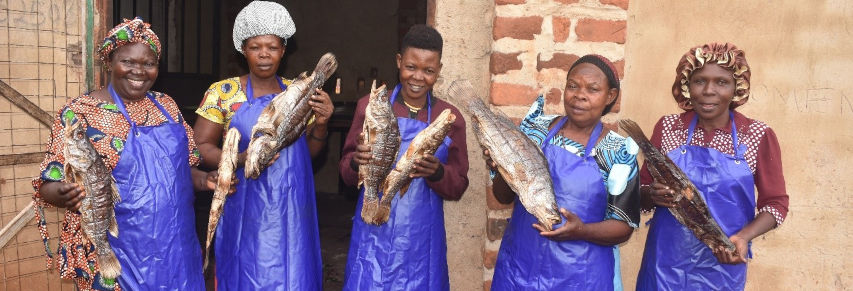 Some members of Kiyindi Women Fish Processor’s Association with their produce. Photo by Abraham Kibirige.