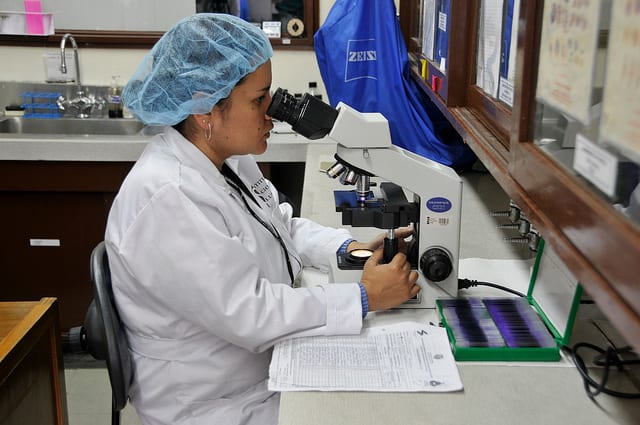 Mujer analista microscopio PAHO