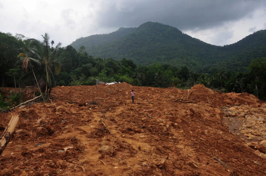 The size of the landslide has never been assessed, but three villages vanished. A man walks across the landslide area.
