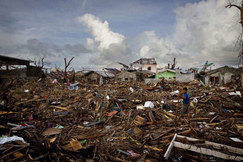 A man sifts through the debris of homes destroyed Typhoon Haiyan