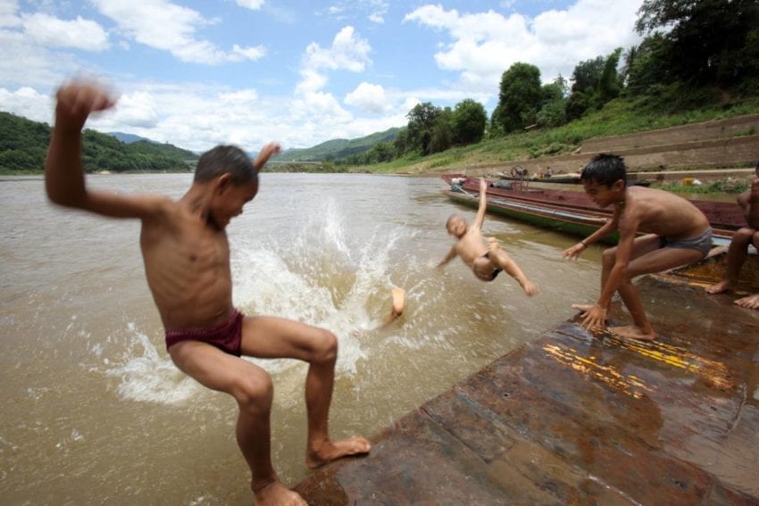 Children play in the Mekong near the dam
