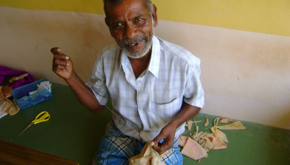 A_old_man_stitching_clothes