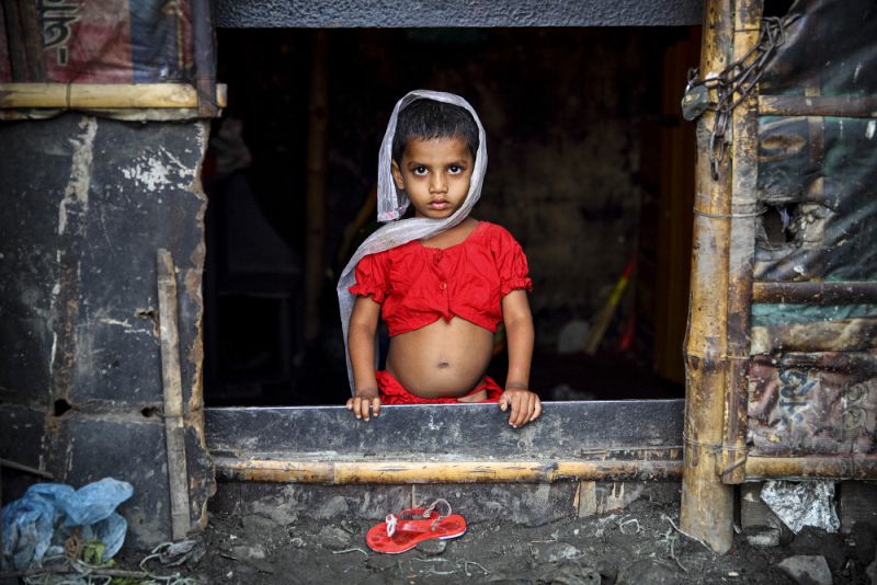 girl looks out from her slum