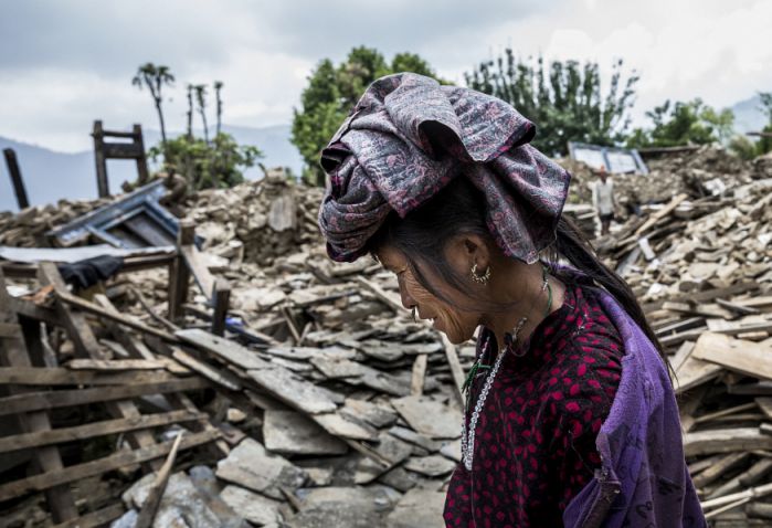woman walks through rubble