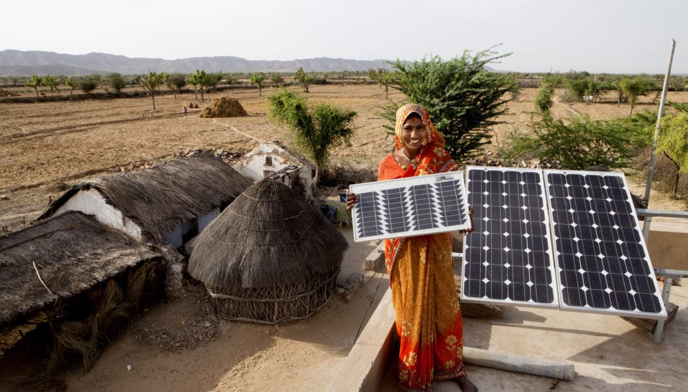 Indian woman holding solar panel