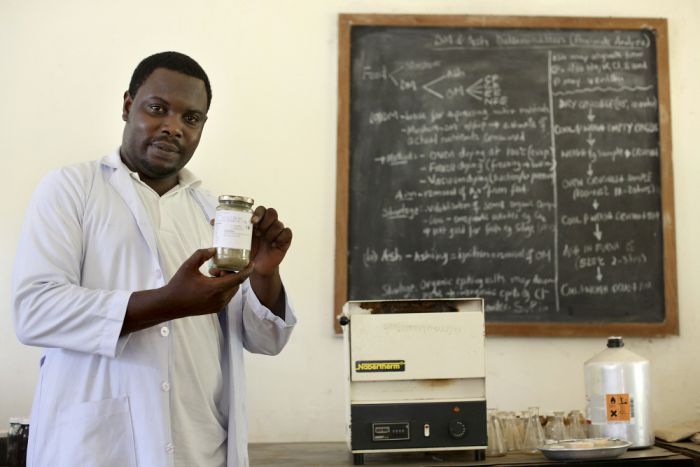 masters_student_holds_a_sample_of_dried_cassava_tops.jpg