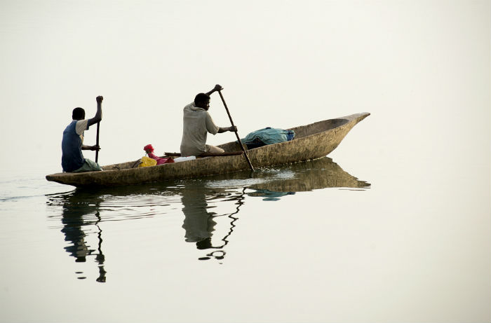 Men depart at dawn in a pirogue to go fishing among the mangrove