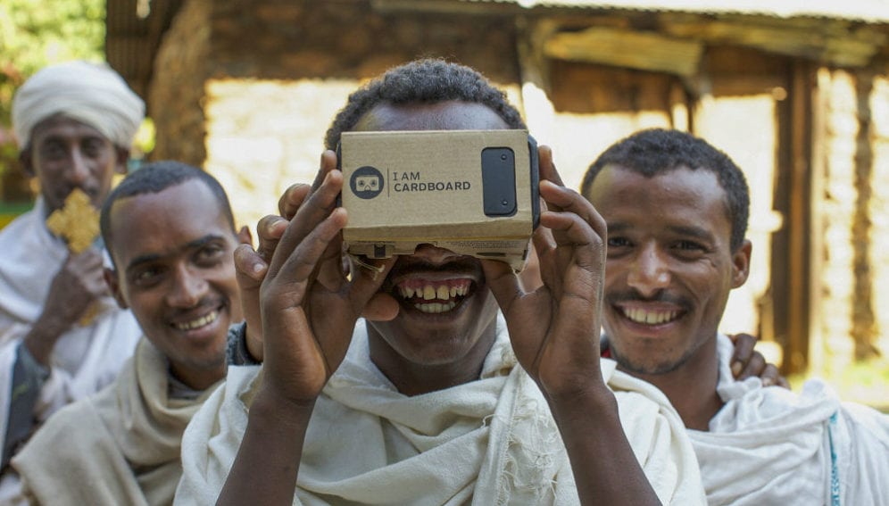 Priests take turns to view a phone within a virtual reality box