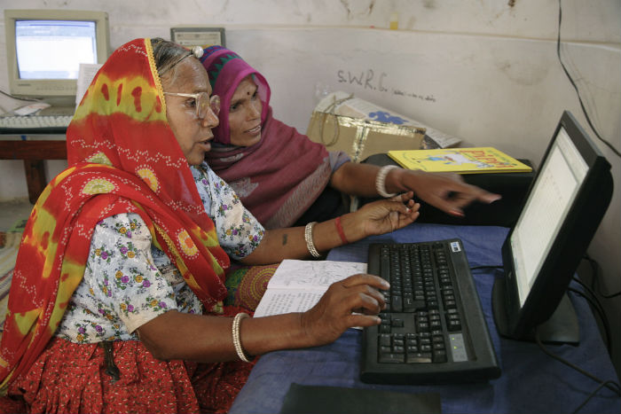 Women sat at a computer in India