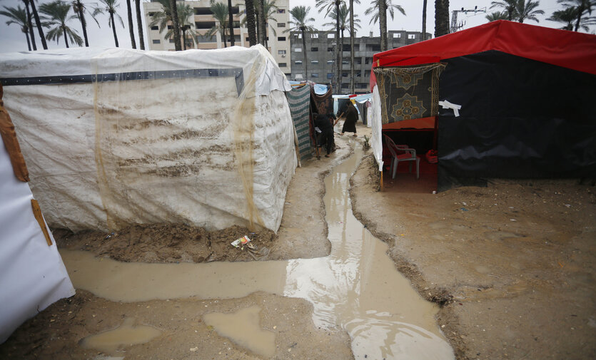They dig channels around the tents to drain the rainwater, with the aim of protecting themselves from flooding
