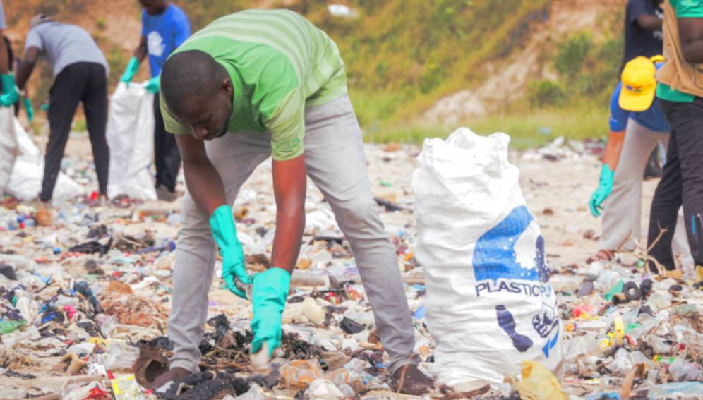 A man, collecting plastic waste at the beach during cleanup exercise in Ghana. Photo by Fquasie