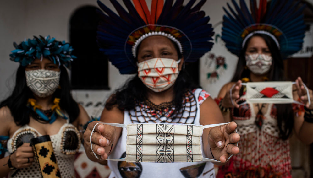 The coordinator of the Association of the Satere-Mawe Indigenous Women (AMISM), Sonia Satere-Mawe, 46, displays with her daughters Samela (right) and Sandiely (left), the face protection masks produced at the association, which is located in the West Zone of Manaus, Amazonas, Brazil on July 21, 2020. (IMF Photo/Raphael Alves)