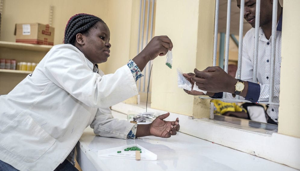 A pharmacy worker dispenses malaria medications