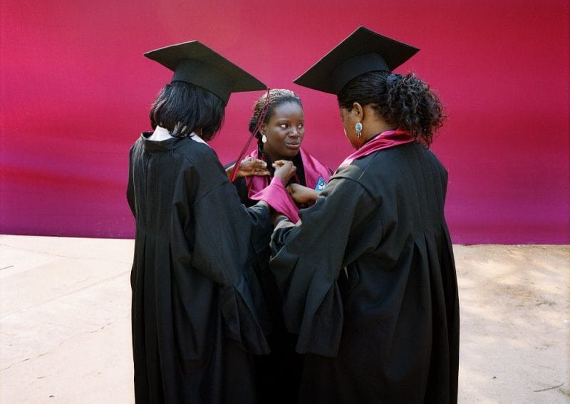 Three female students, wearing gowns and mortar boards