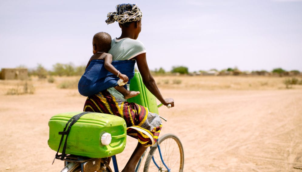 24 years old, rides her bicycle with her baby to collect water for her family