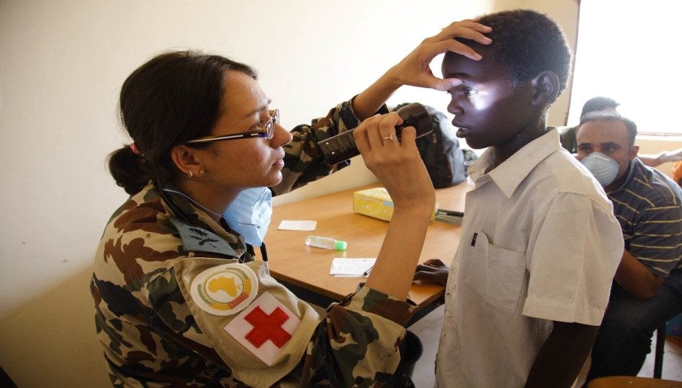 A Nepalese doctor checks the eyes of a Darfurian boy