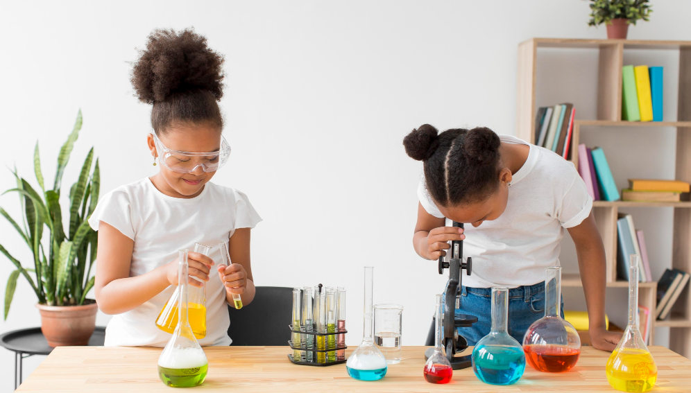 Two girls experimenting with science. [Image by Freepik]