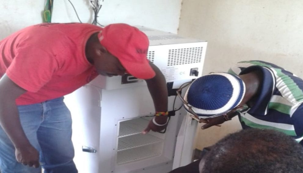 A technician training dispensary worker on use of solar refrigerator in North Eastern Kenya

