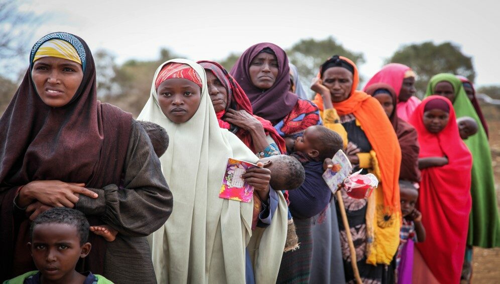 Women and children queue to enter a free medical clinic.