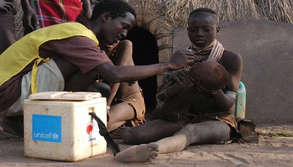 vaccinates child against polio in Karo Duss village