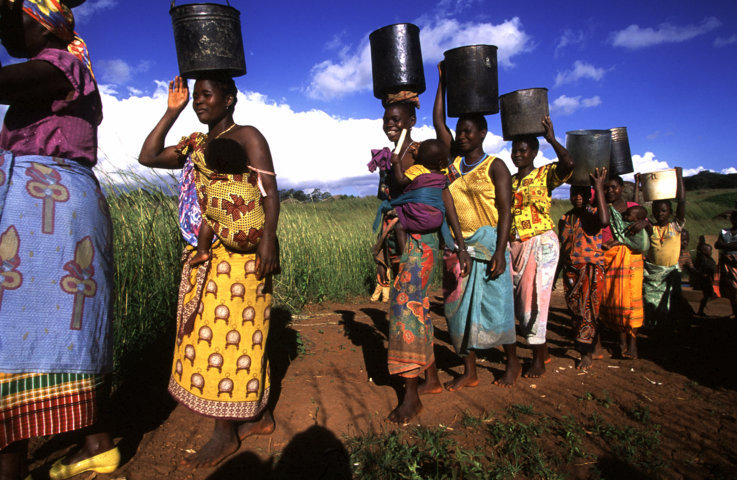 Women carry water from a well in Niassa province in north-west Mozambique. Over half the country’s population lack access to a safe water source. On average, women in Africa and Asia must walk six kilometres to collect water. This significantly reduces how long they can dedicate to agriculture and other income generating activities
