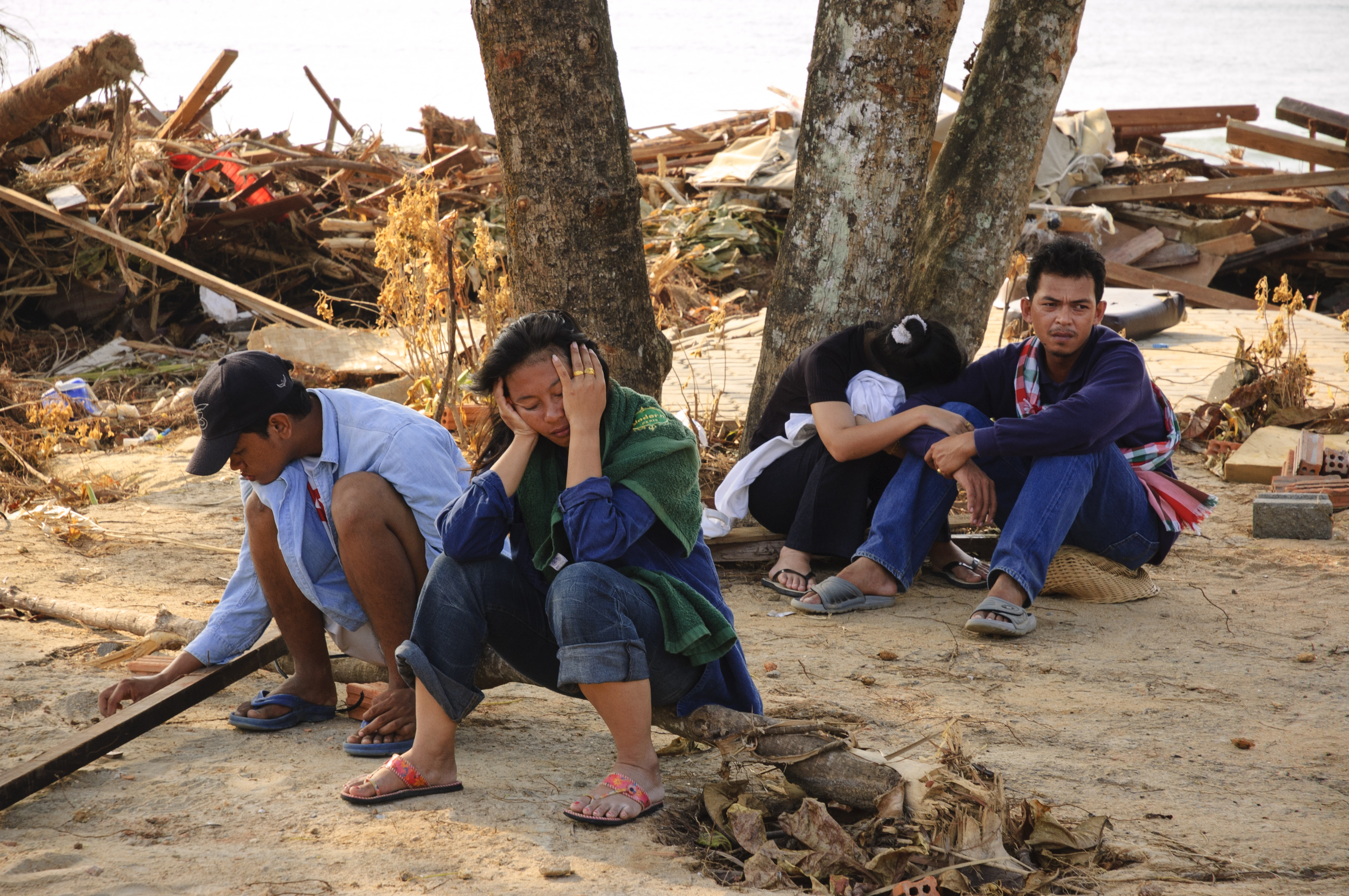 Thai family takes a break from searching for a missing family member at Khao Lak, Thailand following the tsunami