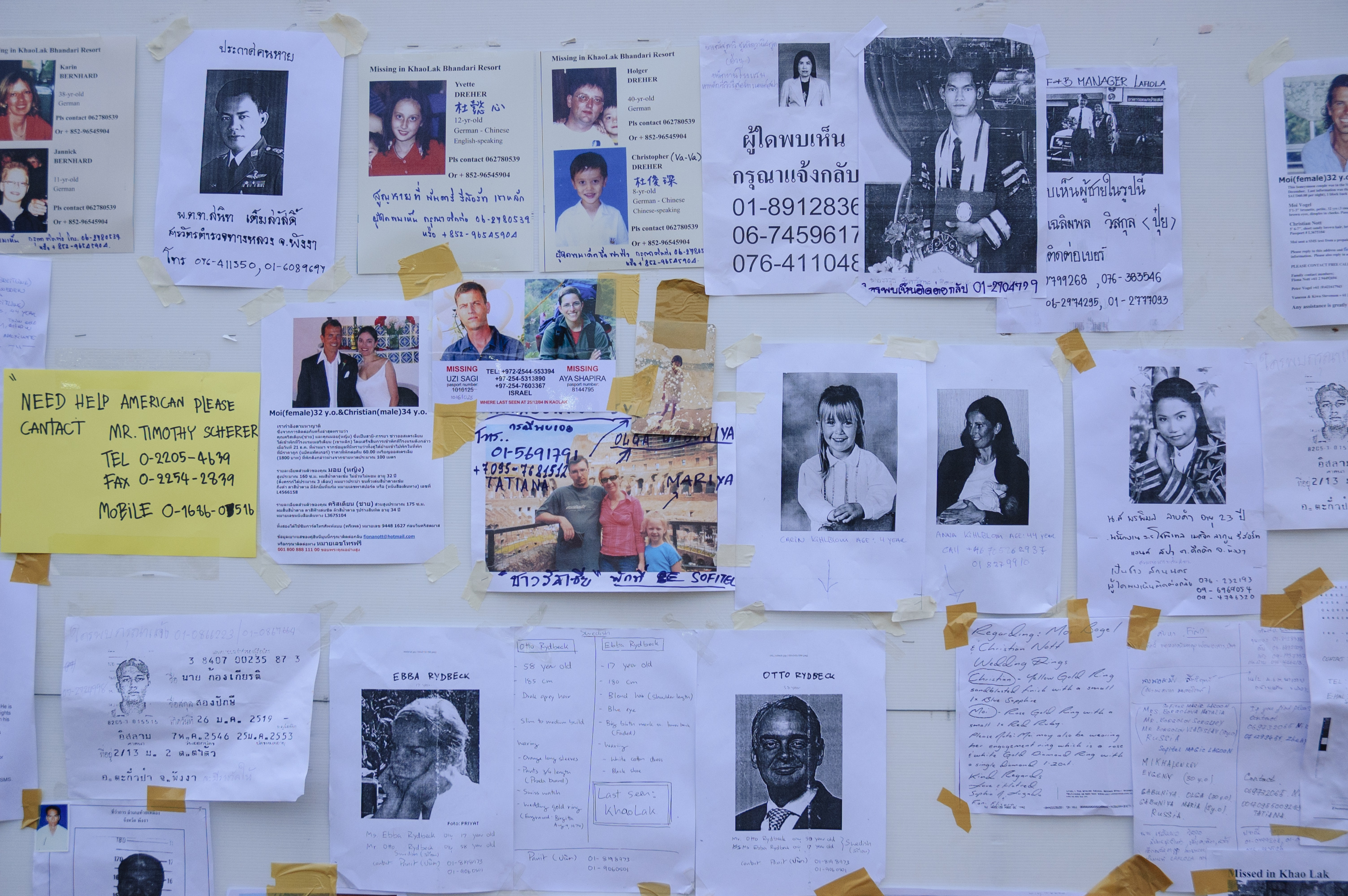 Photos of and messages about missing people line the wall of the information center at Khao Lak