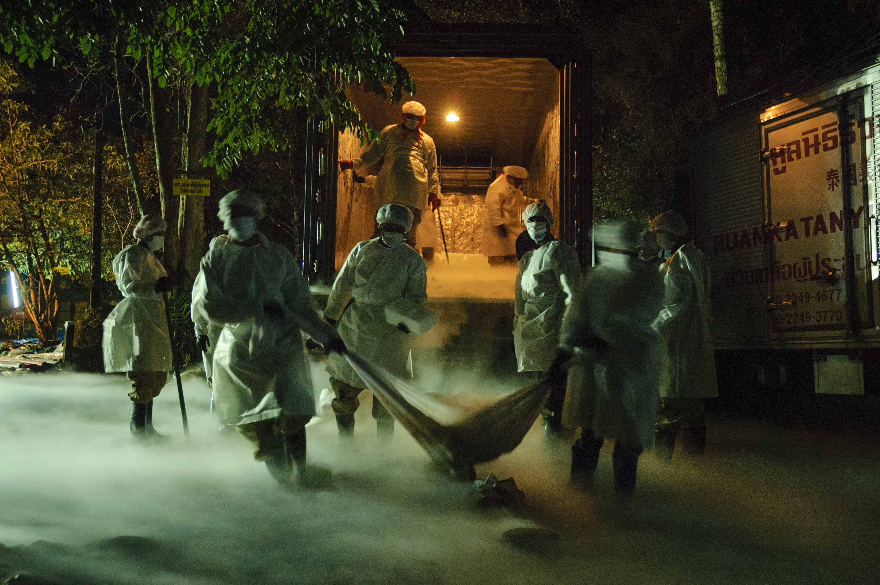 Thai volunteers unload dry ice from a delivery truck at Wat Bang Muang near Khao Lak. The ice will be used to slow the decomposition of the bodies of tsunami victims