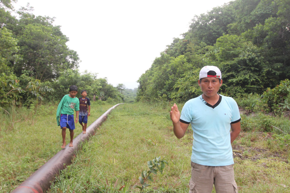 Elías Wasún, president of the Wampis indigenous community of Mayuriaga, stands on the pipeline that carries crude past his village from oil fields in Peru. A spill 13 km on the community's land, fouled a stream where residents and neighboring villages have traditionally fished and hunted. 

