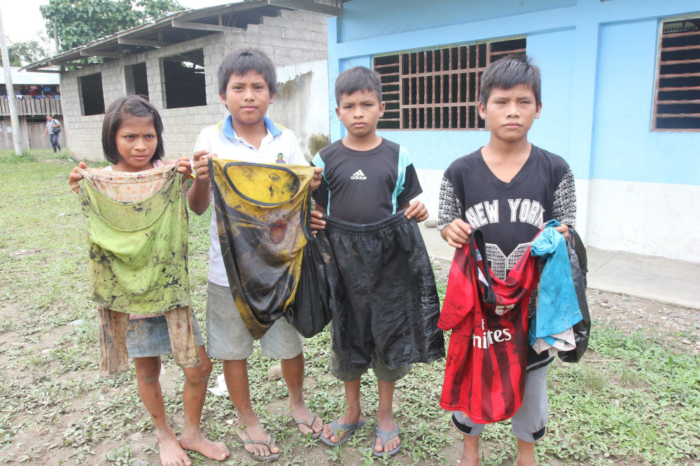 Children in the Awajún indigenous community of Nazareth display the clothes they were wearing when they scooped oil out of the river after a spill from a pipeline operated by Peru's state-run oil company, Petroperú. 
