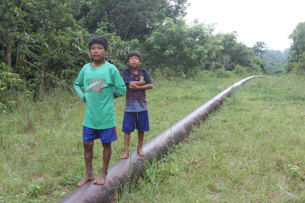 Children walk along a spur of the oil pipeline that carries crude across Peru.. The northern spur passes through the Wampis indigenous community of Mayuriaga, where about 1,000 barrels of oil spilled in early February, fouling land and streams. 
