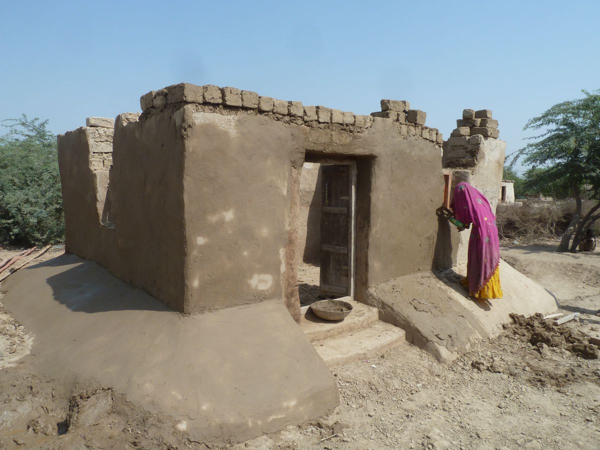 A woman plastering walls of the home she has built after having made and laid the blocks at a Hindi village in Umerkot district, southeastern Sindh. The project, managed by the International Organization for Migration (IOM), trained equal numbers of men and women, so it was common to find women in charge of reconstruction work
