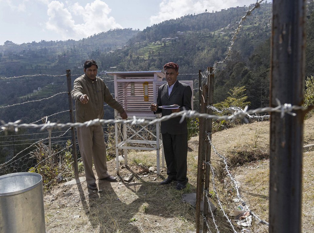 A science teacher (left) and the headteacher of the Shree Hanuman Secondary School collect rainfall and temperature readings. This data will be shared with the International Centre for Integrated Mountain Development, one of the organisations behind the Climate Smart Villages project, which will use it to study local weather patterns
